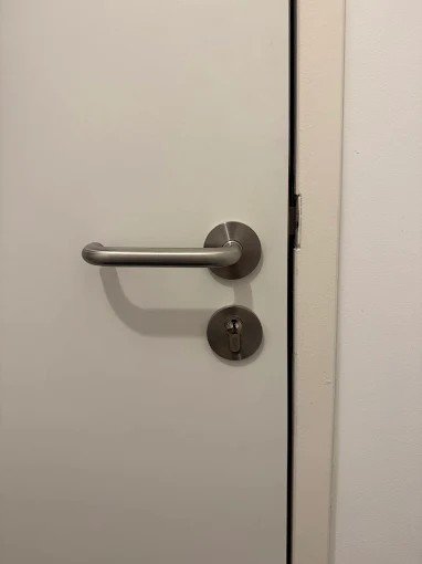 Poignée et cylindre sur une porte blanche