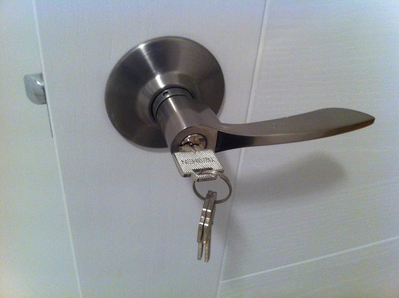 Clé engagée dans la serrure d'une poignée de porte