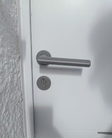 Poignée et cylindre sur une porte d'appartement grise